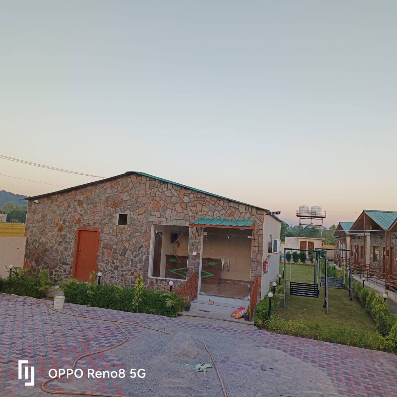 A row of furnished cottages around a landscaped path.